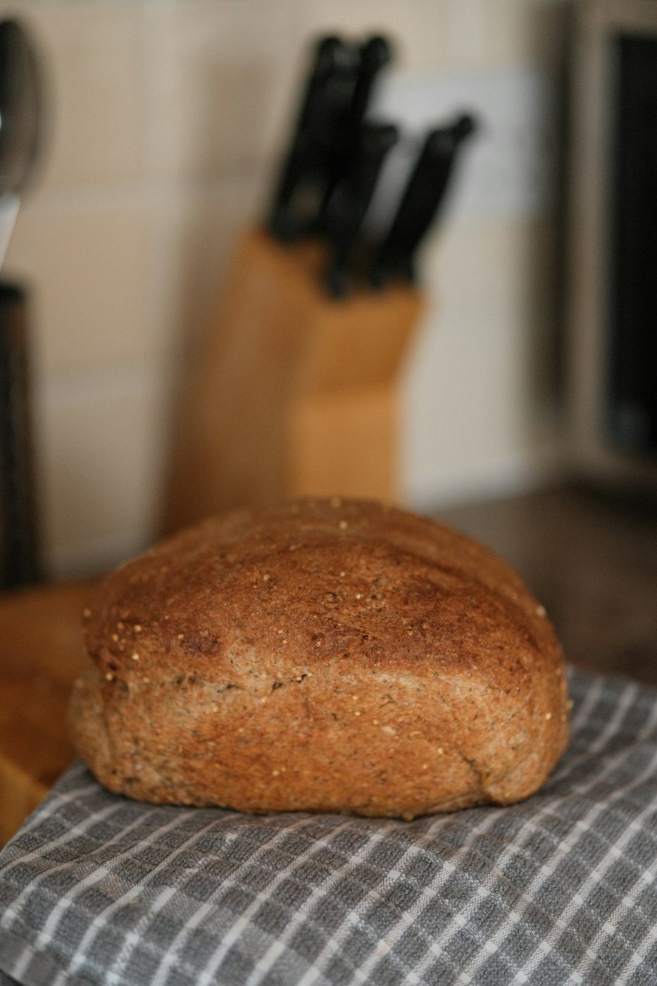 A round homemade loaf resting on a striped kitchen cloth.